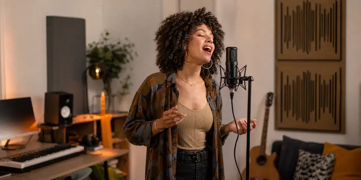 A singer recording vocals in a studio microphone for the Bruno Mars Vocal Style Guide