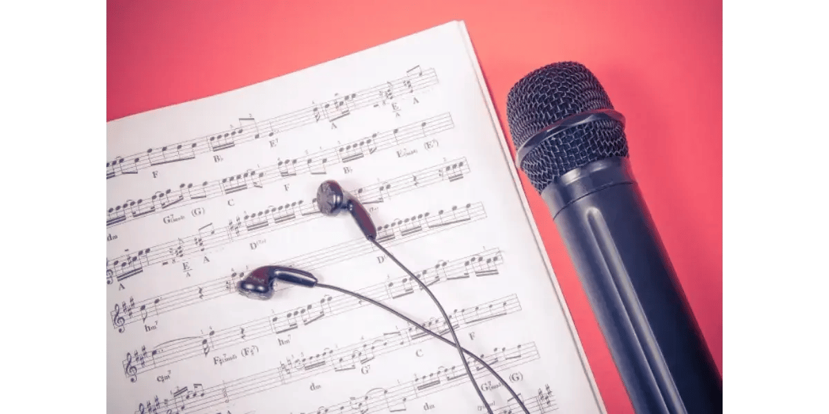 A microphone on sheet music, representing vocal technique and moving smoothly between registers.
