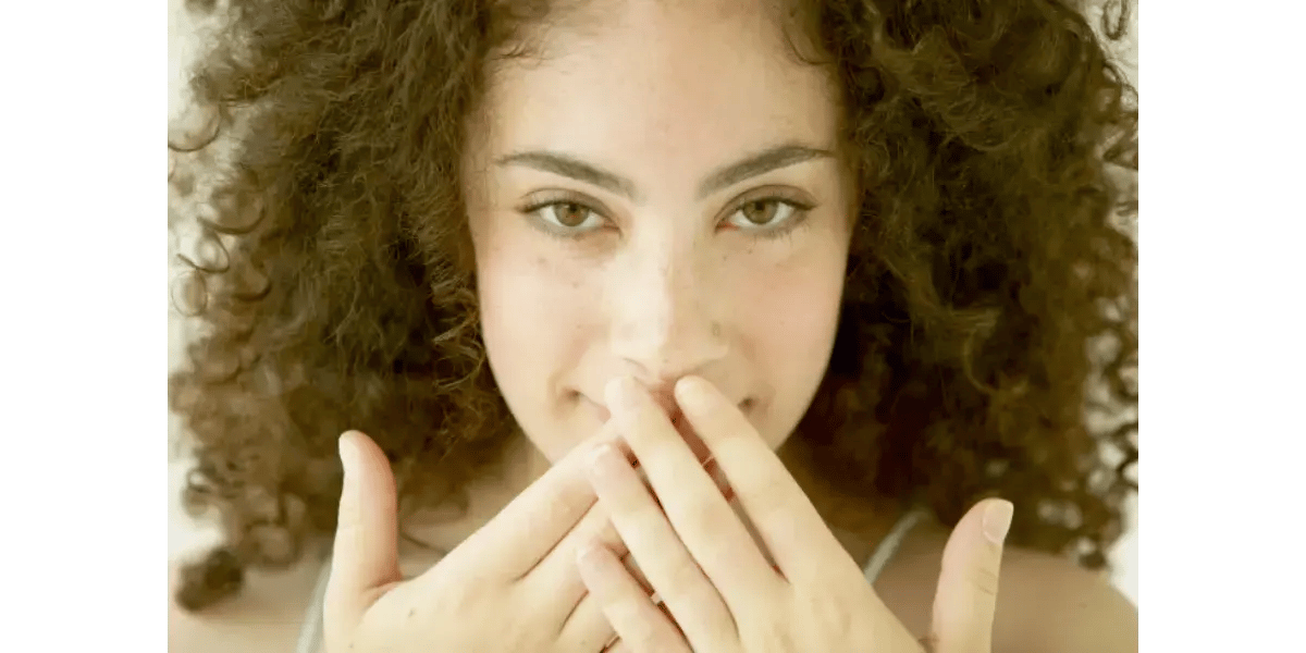 Close-up of a singer with hands on her neck, representing throat tightening and vocal constriction.