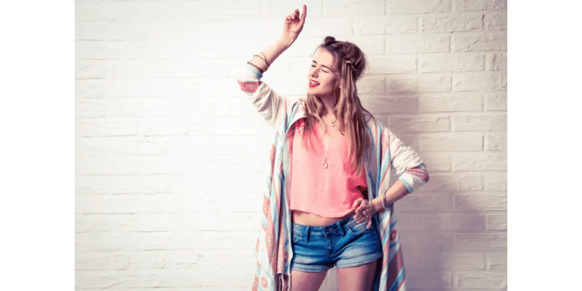 A young singer confidently hitting a high note with her arms raised, representing vocal freedom and range expansion.