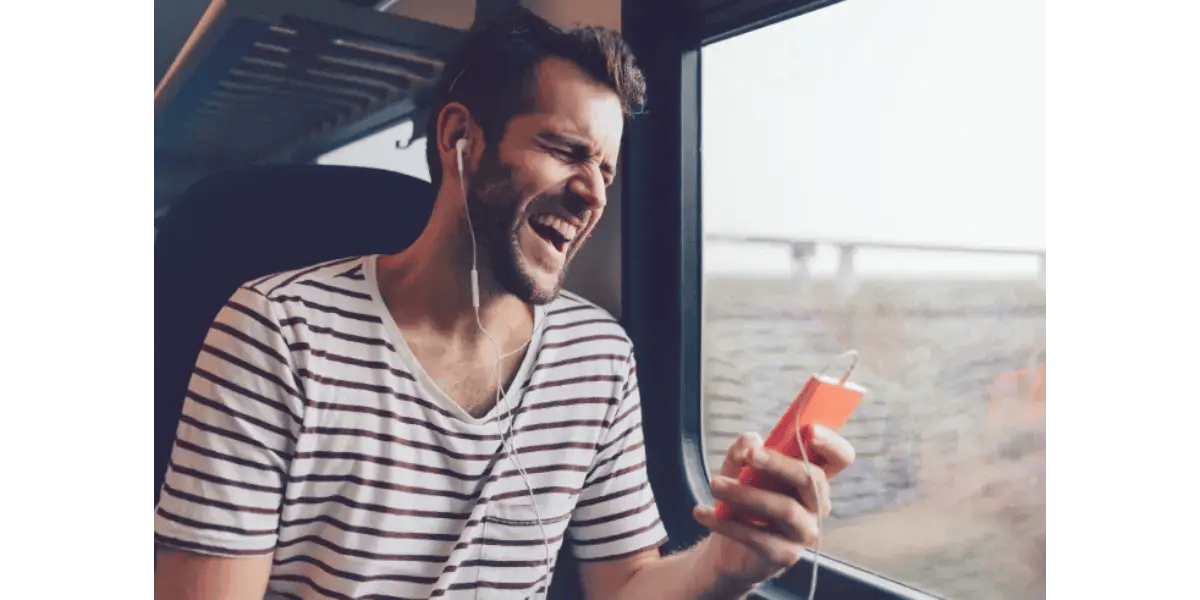 Man singing passionately while holding a smartphone and headphones