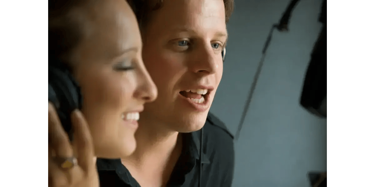 A male and female singer practicing daily vocal exercises side-by-side to build consistency.