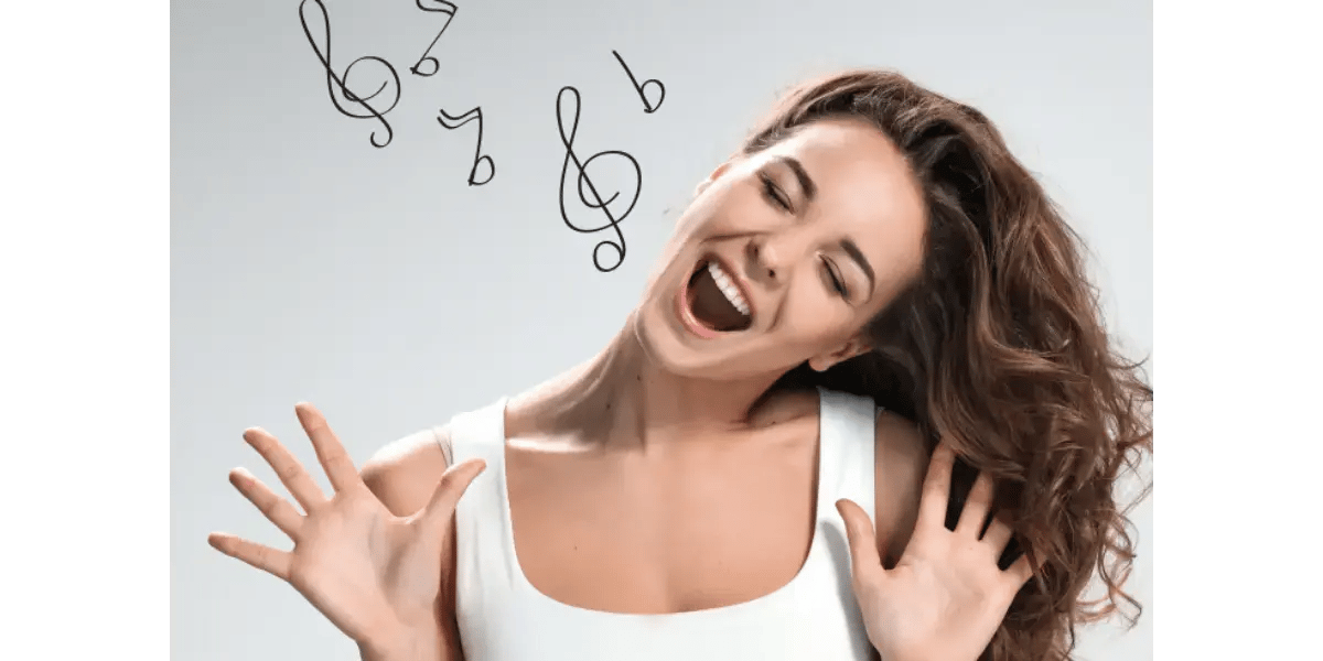 A woman singing happily, representing healthy vocal technique and coordination.