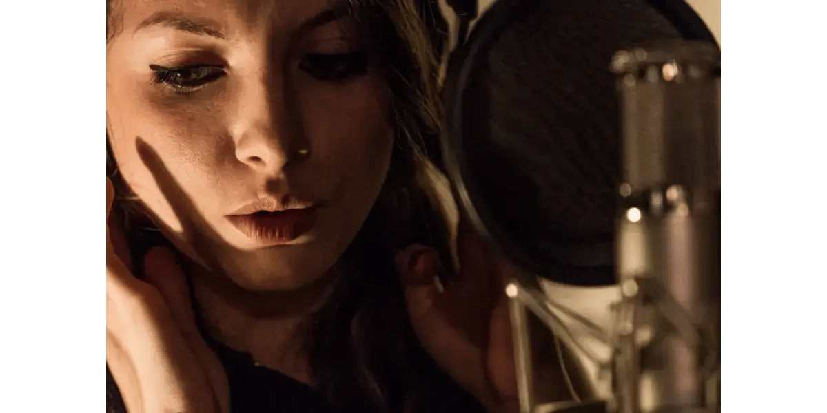A close-up of a singer in moody lighting, representing isolated falsetto registration and vocal exercises.