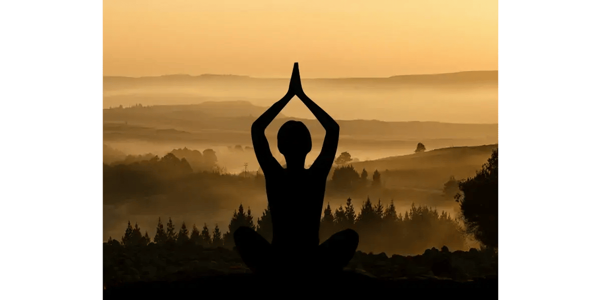 A silhouette of a person meditating against a sunset, representing the mindfulness and relaxation of vocal tonal play.