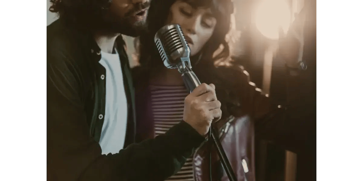 A vocalist practicing singing techniques to properly coordinate falsetto and chest voice without constriction.