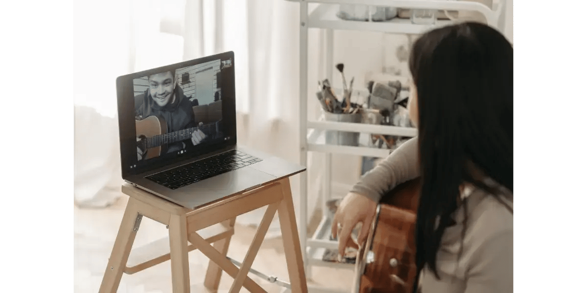 Adult student taking a live online singing lesson with a vocal coach on a video call at home