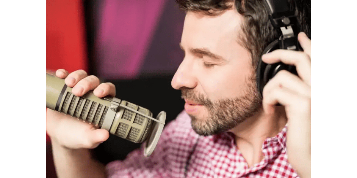 A male vocalist practicing singing techniques with a vintage silver microphone.