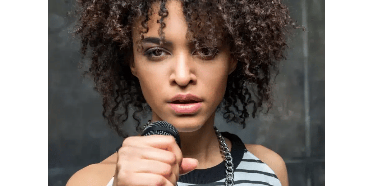 A singer holding a clenched fist to their chest, representing the solid, "flexibly firm" foundation of the middle voice register.