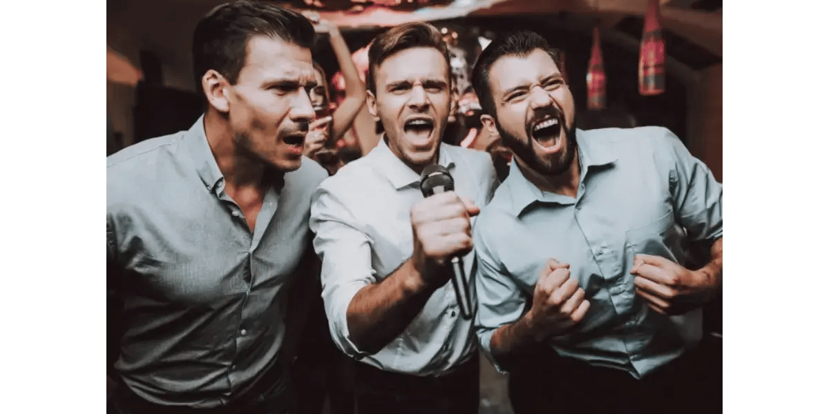 Three men singing passionately into microphones with their mouths wide open, representing vowel formation and vocal mechanics.