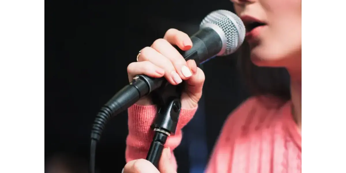 A singer holding a microphone, representing the lightness and flexibility of falsetto dominated registration.