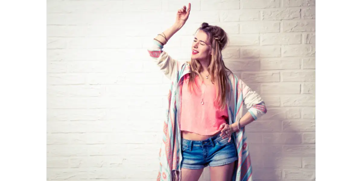 A confident woman raising her arm, representing the vocal power and stability gained from singing in your chest voice.