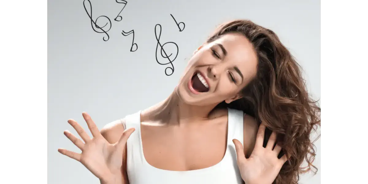 A woman singing happily, representing healthy vocal technique and coordination.