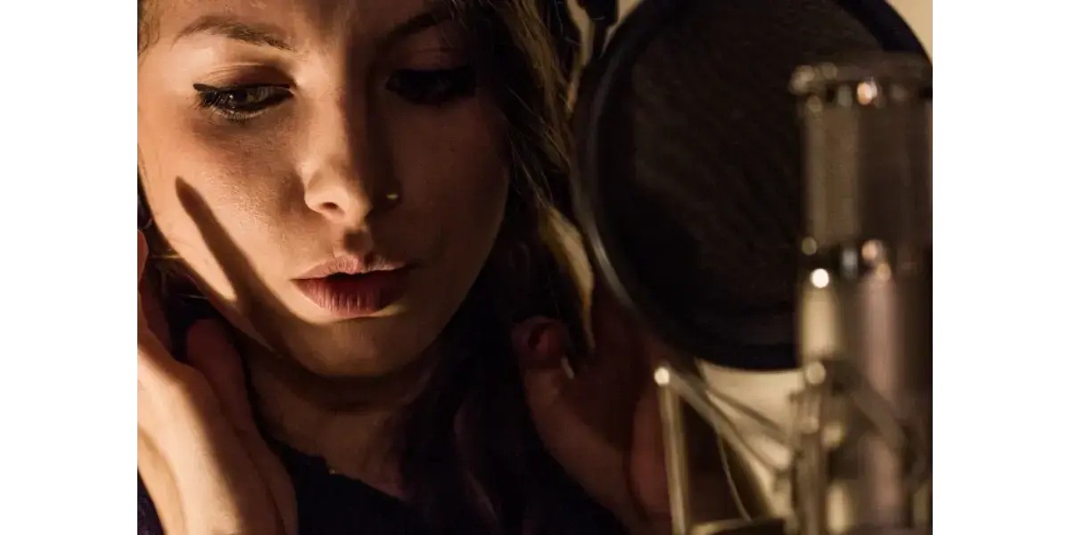 A close-up of a singer in moody lighting, representing isolated falsetto registration and vocal exercises.