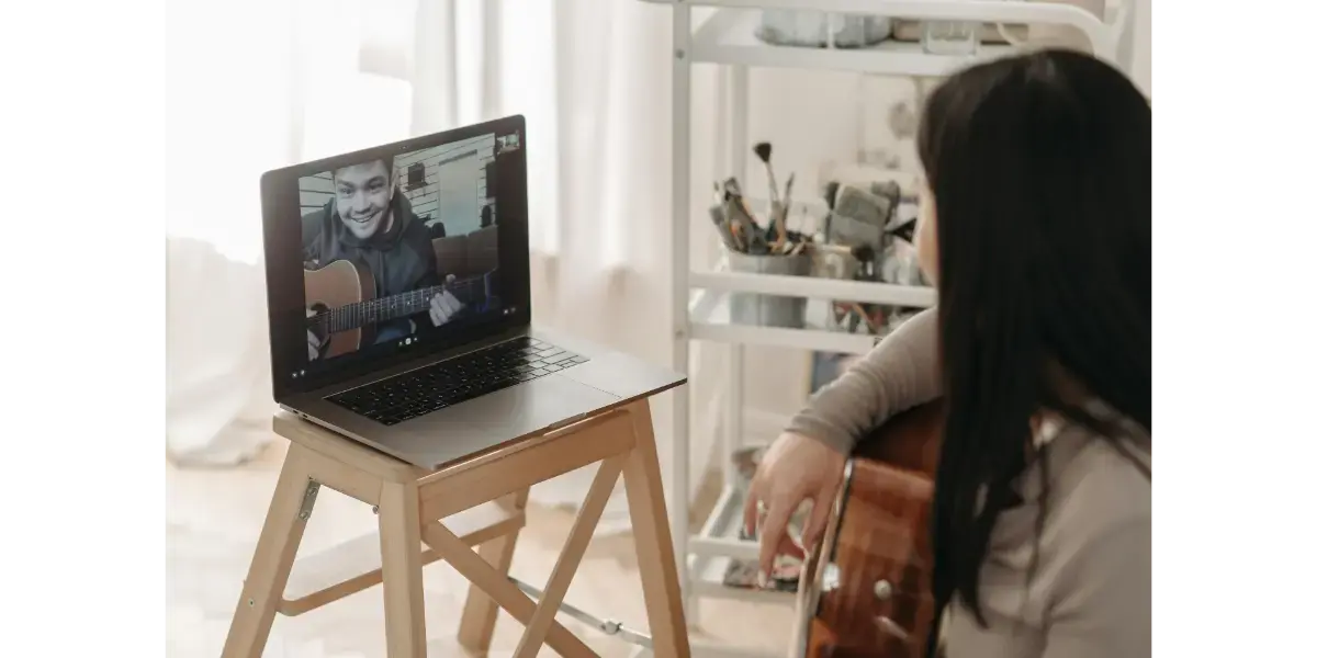 Adult student taking a live online singing lesson with a vocal coach on a video call at home