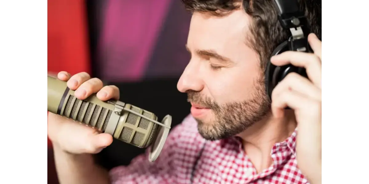 A male vocalist practicing singing techniques with a vintage silver microphone.